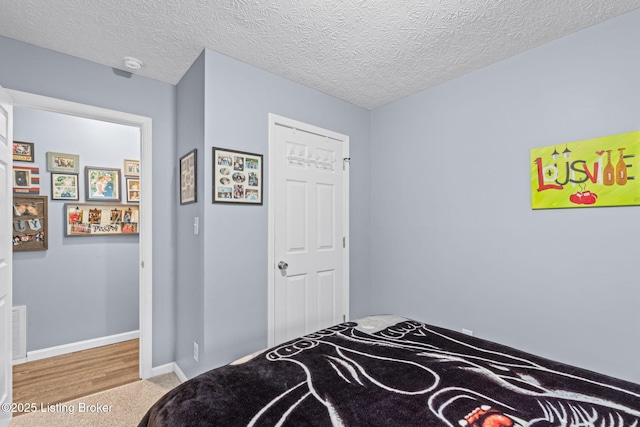 carpeted bedroom featuring a textured ceiling