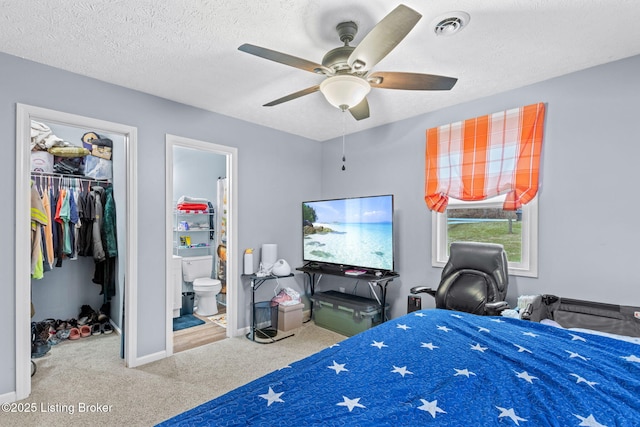 carpeted bedroom featuring connected bathroom, ceiling fan, a spacious closet, a textured ceiling, and a closet