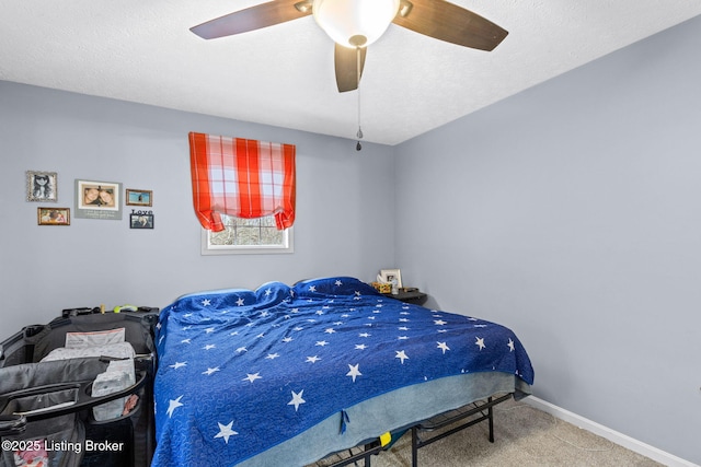 bedroom featuring carpet flooring, a textured ceiling, and ceiling fan