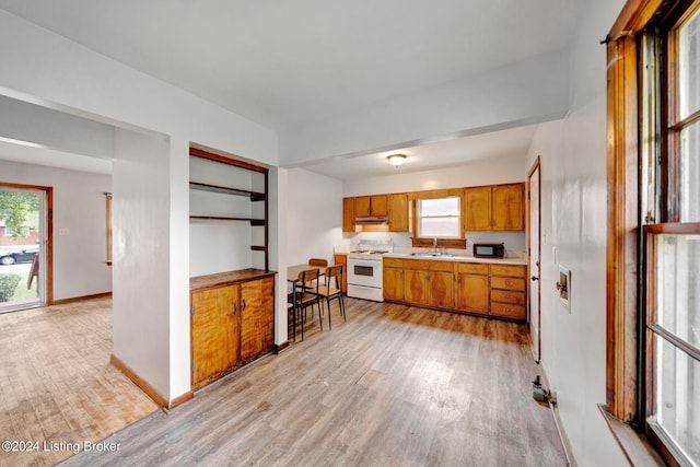 kitchen featuring white range, light hardwood / wood-style flooring, and sink