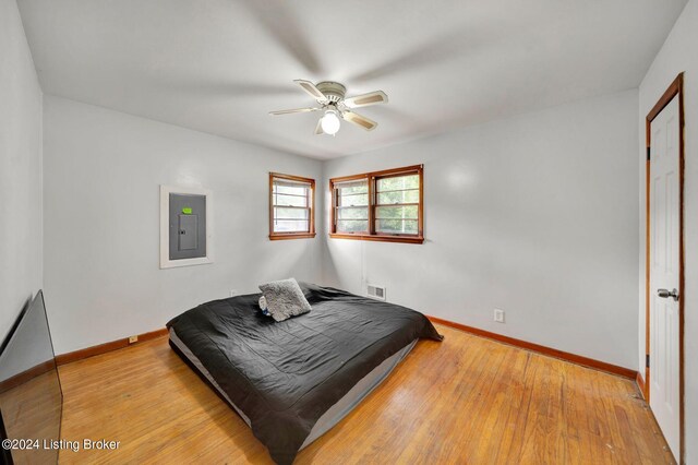 bedroom featuring electric panel, ceiling fan, and light hardwood / wood-style floors