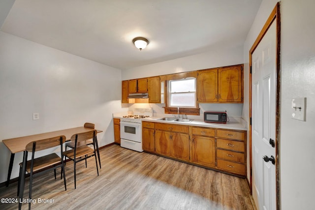 kitchen with light wood-type flooring, sink, and gas range gas stove