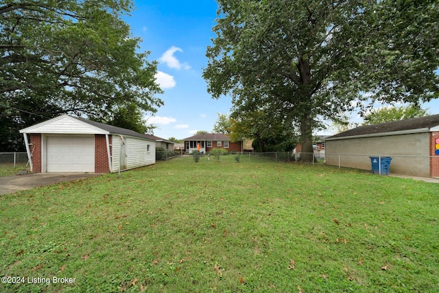 view of yard with a garage and an outbuilding