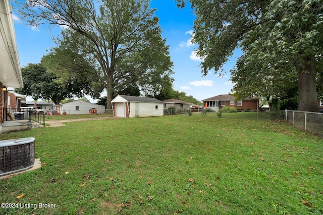 view of yard featuring an outdoor structure, a garage, and central air condition unit