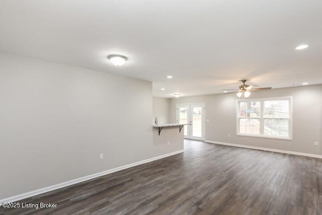 unfurnished living room featuring ceiling fan, dark hardwood / wood-style flooring, and french doors