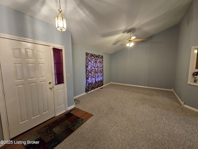 carpeted entryway featuring ceiling fan and vaulted ceiling