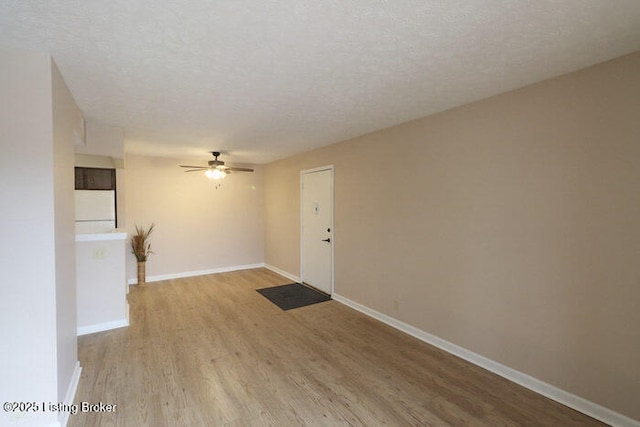 unfurnished room featuring ceiling fan, a textured ceiling, and light hardwood / wood-style flooring