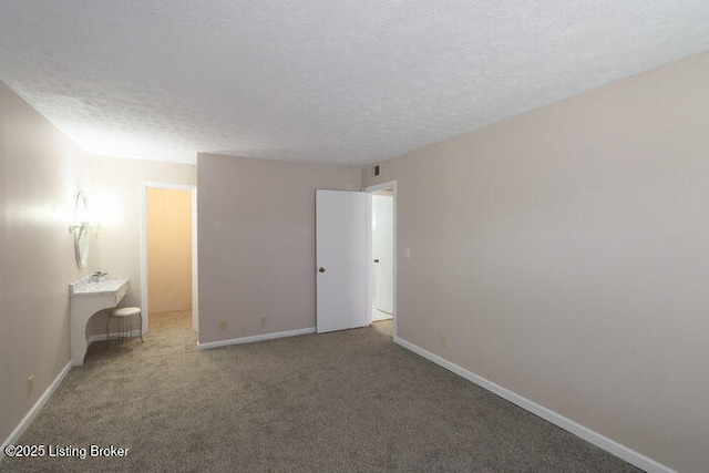 carpeted spare room featuring a textured ceiling