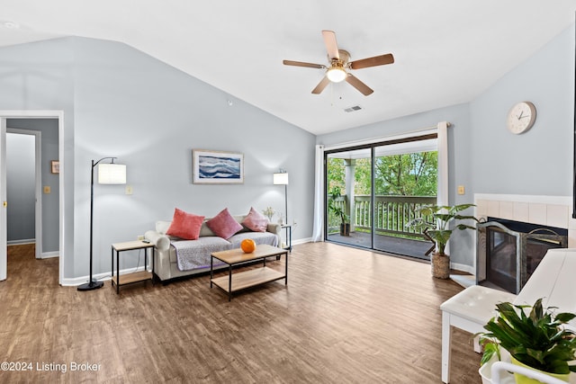 living room featuring hardwood / wood-style flooring, ceiling fan, lofted ceiling, and a fireplace