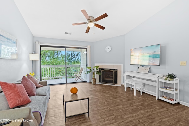 living room with dark hardwood / wood-style floors, ceiling fan, and a tile fireplace