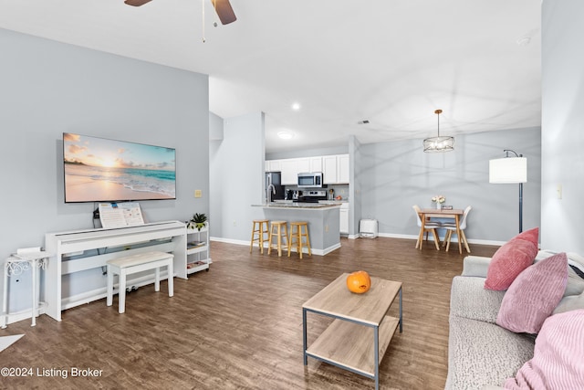 living room with ceiling fan and dark wood-type flooring