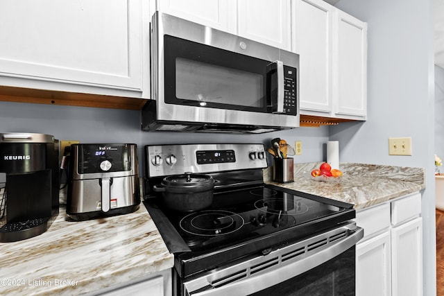 kitchen featuring white cabinets, light stone countertops, and appliances with stainless steel finishes