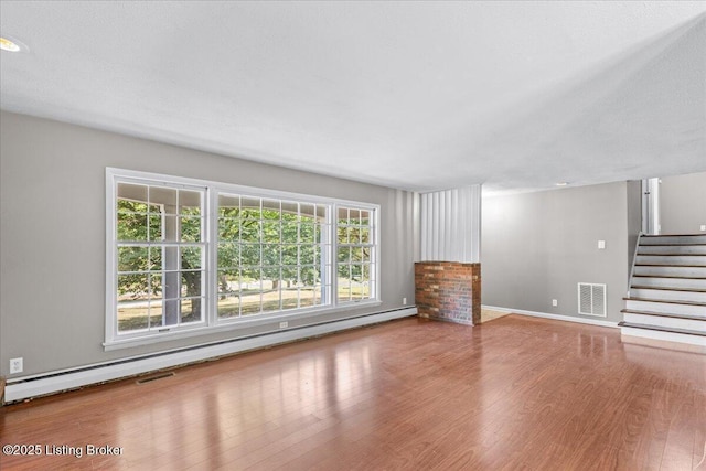 unfurnished living room with a baseboard radiator and hardwood / wood-style flooring