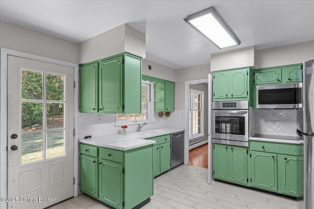 kitchen featuring green cabinets, sink, stainless steel appliances, and tasteful backsplash