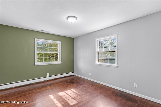 spare room featuring dark hardwood / wood-style flooring and baseboard heating