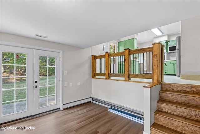 doorway with french doors, baseboard heating, and wood-type flooring