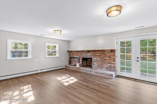 unfurnished living room with a fireplace, french doors, light hardwood / wood-style flooring, and baseboard heating