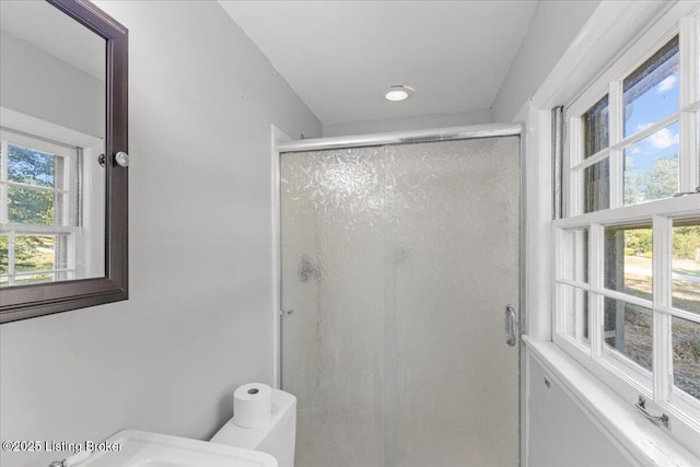 bathroom with toilet and a shower with shower door