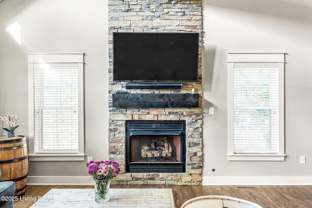 living room featuring hardwood / wood-style flooring and a stone fireplace