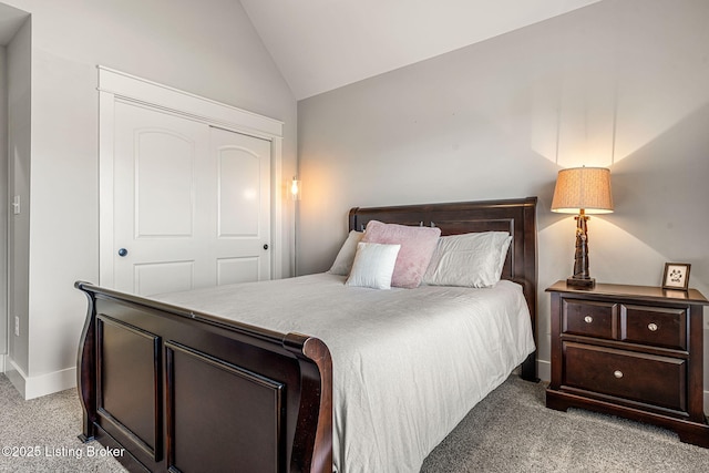 bedroom with vaulted ceiling, light carpet, and a closet