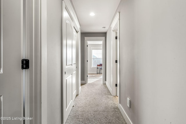 hallway featuring light colored carpet