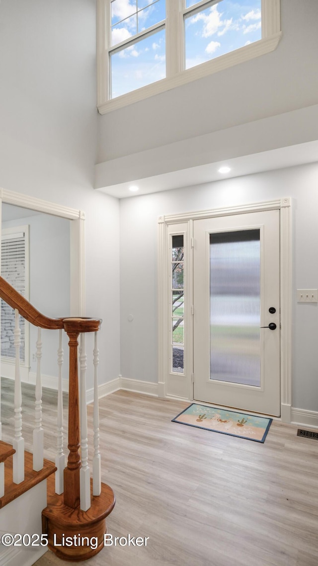 entrance foyer with light wood-type flooring and a high ceiling