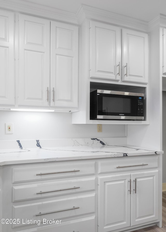 kitchen with white cabinetry and light stone counters