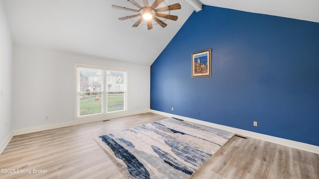 empty room with vaulted ceiling with beams, ceiling fan, and light hardwood / wood-style floors