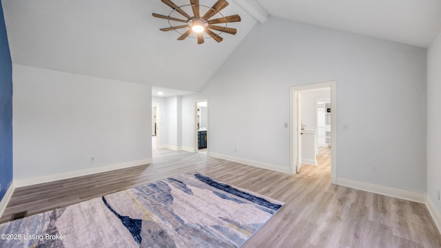 empty room featuring ceiling fan, light hardwood / wood-style flooring, high vaulted ceiling, and beamed ceiling