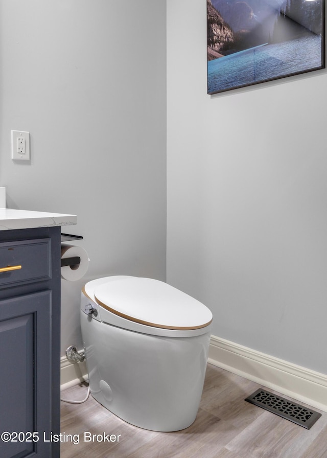 bathroom featuring vanity, toilet, and wood-type flooring