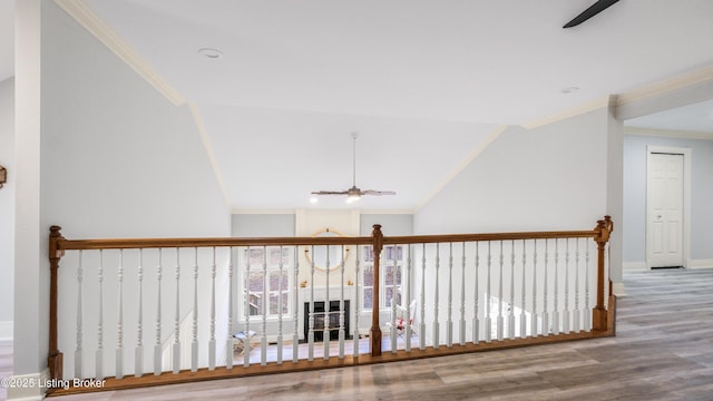 corridor with hardwood / wood-style flooring, lofted ceiling, and crown molding