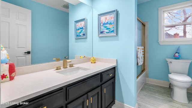 full bathroom with vanity, wood-type flooring, shower / bath combination with glass door, and toilet