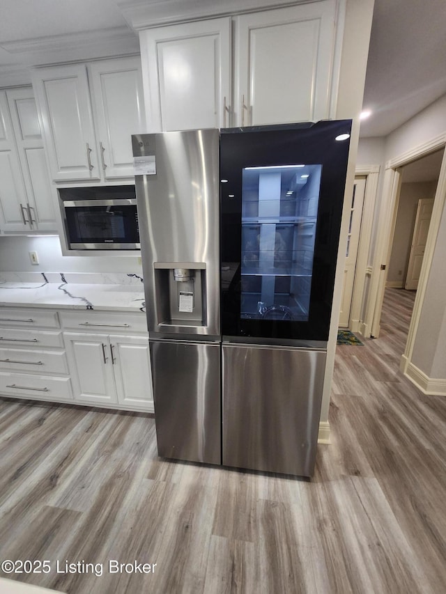 kitchen with white cabinetry, appliances with stainless steel finishes, and light hardwood / wood-style flooring