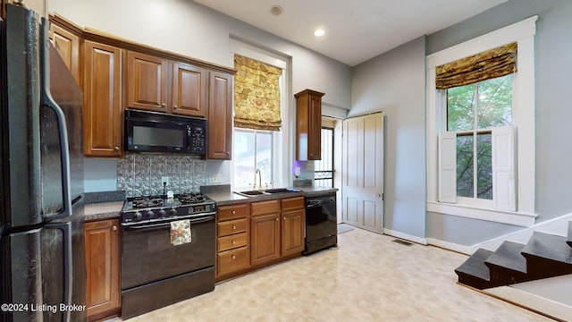 kitchen featuring backsplash, sink, and black appliances