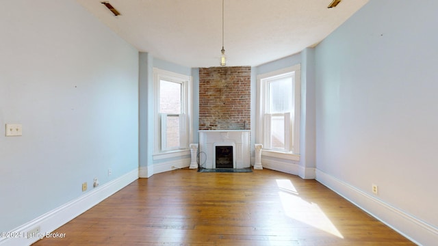 unfurnished living room with hardwood / wood-style floors and a healthy amount of sunlight