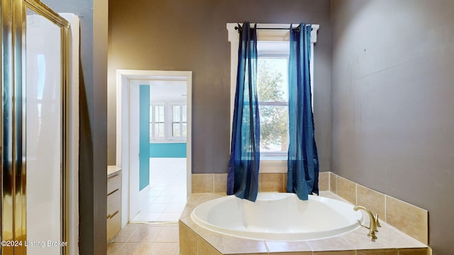 bathroom featuring tile patterned floors, vanity, and tiled tub