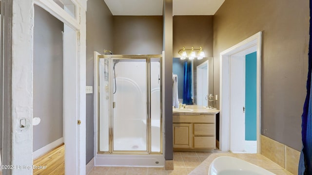 bathroom featuring plus walk in shower, vanity, and tile patterned flooring