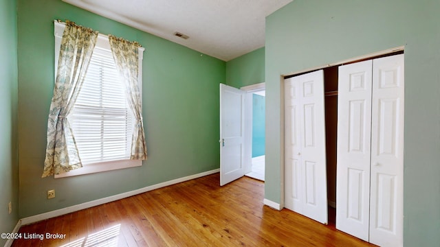 unfurnished bedroom with hardwood / wood-style flooring and a closet