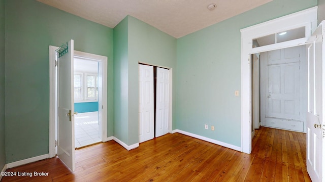 unfurnished bedroom featuring wood-type flooring and a closet