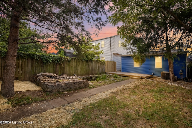 yard at dusk featuring a wooden deck