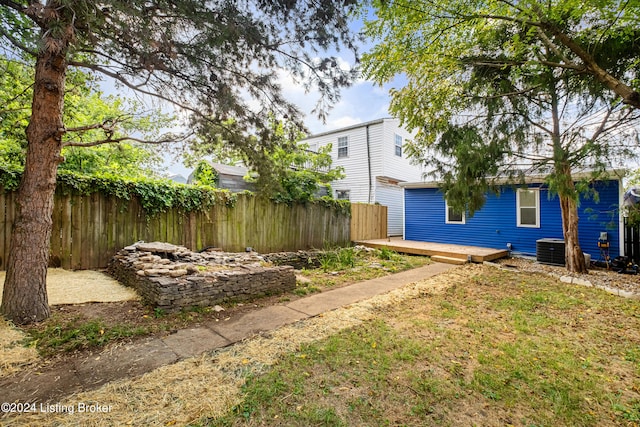 view of yard featuring a deck and central AC unit