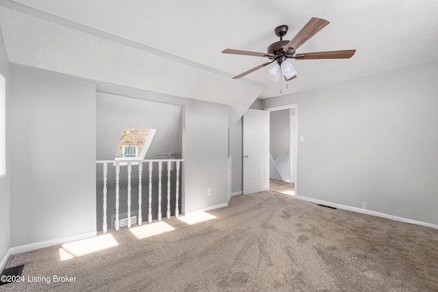 spare room with ceiling fan, carpet, and a textured ceiling