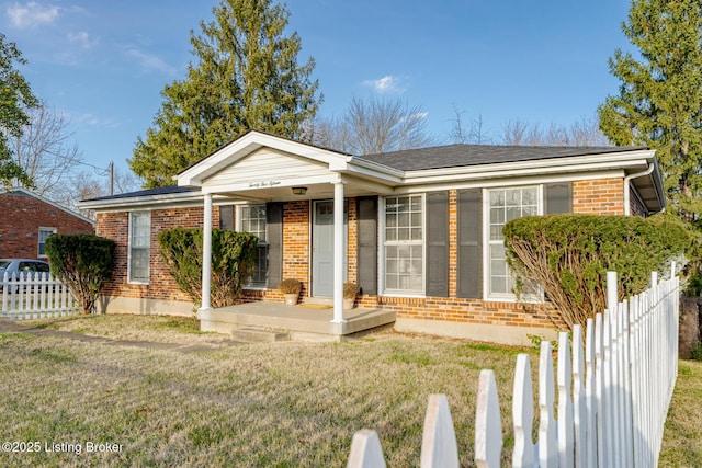 ranch-style home featuring covered porch and a front lawn