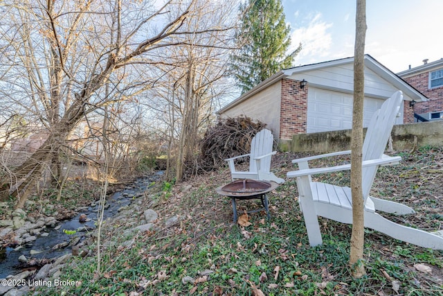 view of yard featuring a fire pit and a garage