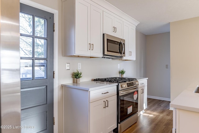 kitchen featuring white cabinetry, dark wood-type flooring, and stainless steel appliances