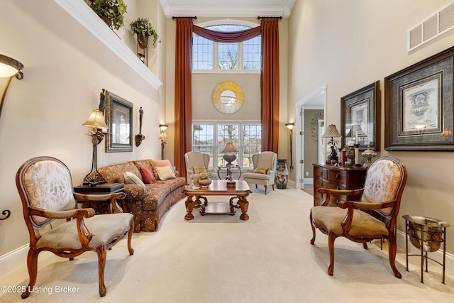 living room featuring light carpet, crown molding, and a high ceiling