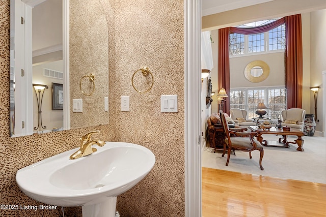 bathroom featuring hardwood / wood-style flooring, sink, and crown molding