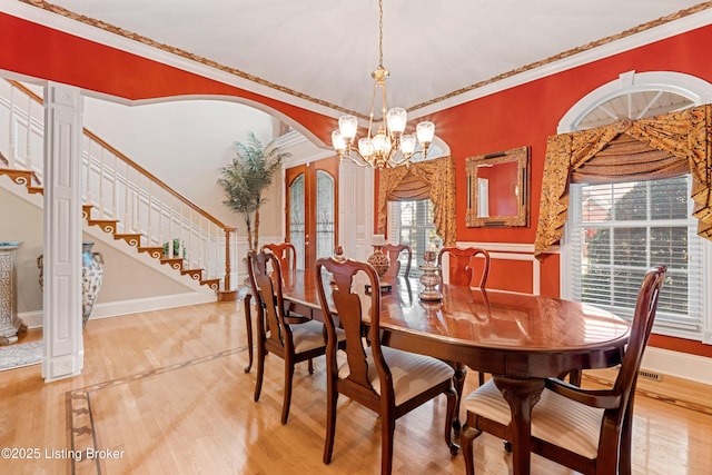 dining space featuring a chandelier, french doors, hardwood / wood-style flooring, and ornamental molding