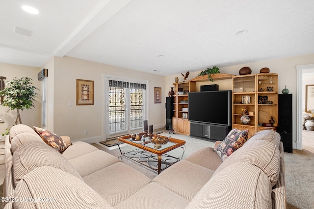 carpeted living room with beam ceiling