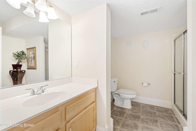 bathroom with vanity, toilet, and a shower with shower door